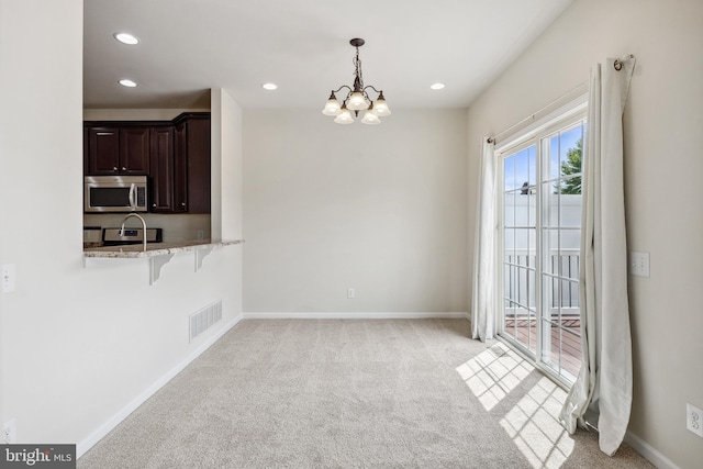 unfurnished dining area featuring recessed lighting, a notable chandelier, light colored carpet, visible vents, and baseboards