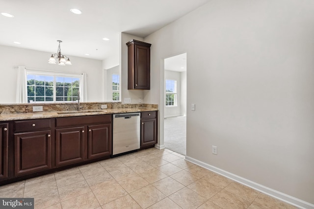 kitchen featuring dark brown cabinetry, a sink, baseboards, stainless steel dishwasher, and light stone countertops