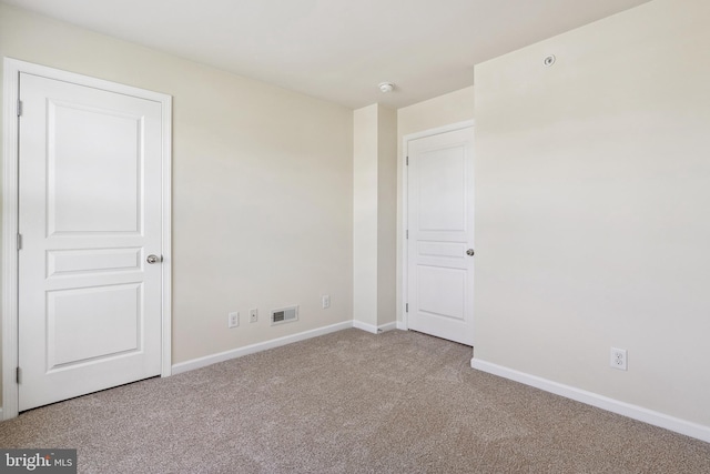 unfurnished bedroom with carpet, visible vents, and baseboards