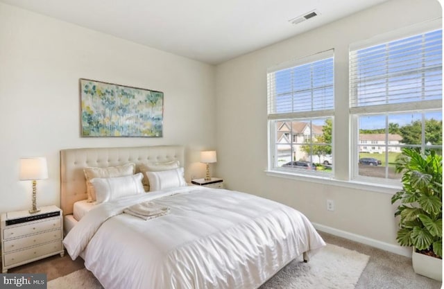 carpeted bedroom with visible vents and baseboards