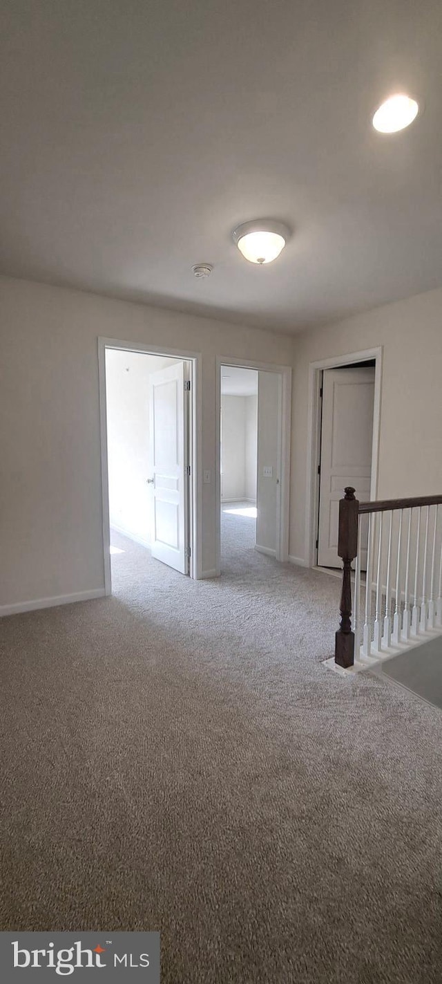 carpeted empty room with baseboards