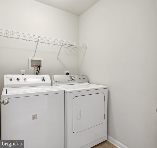 washroom with baseboards, laundry area, and washer and dryer