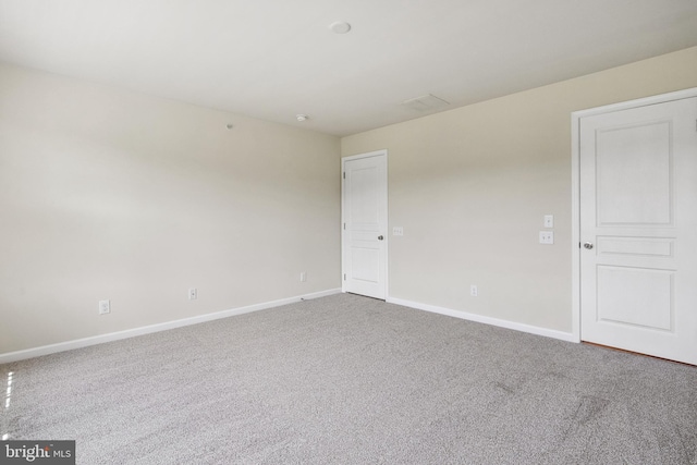 carpeted spare room featuring baseboards