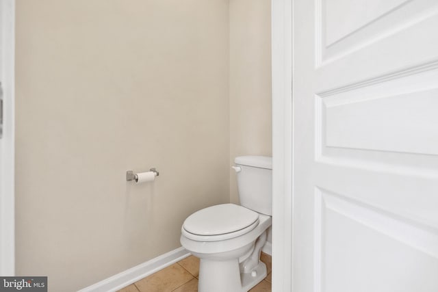 bathroom featuring baseboards, toilet, and tile patterned floors