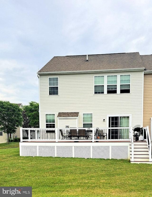 back of house featuring a lawn and a wooden deck