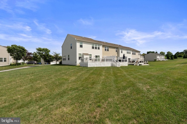 back of property featuring a lawn and a wooden deck