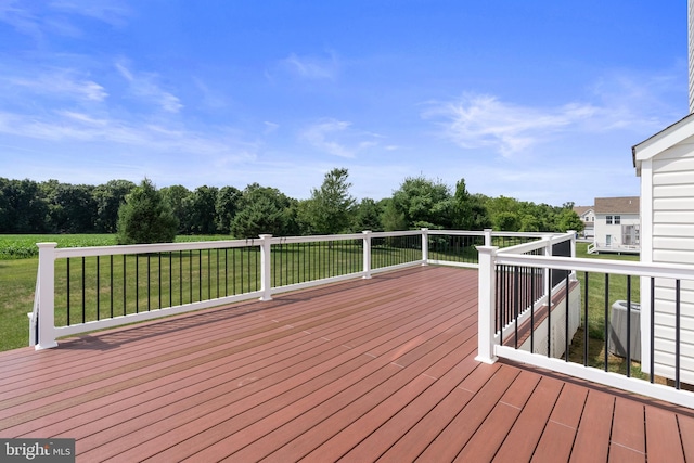 wooden deck featuring a lawn and central air condition unit