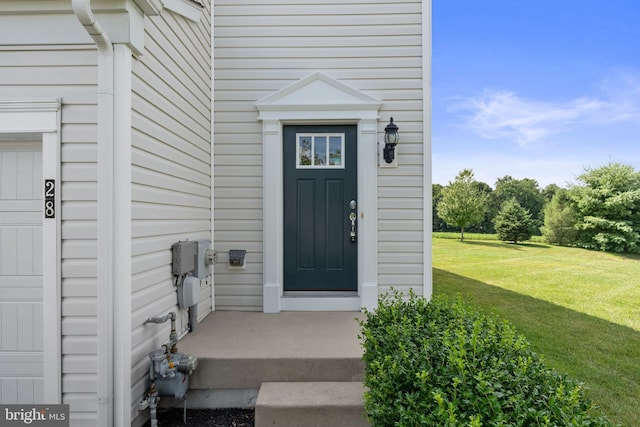 property entrance with a lawn