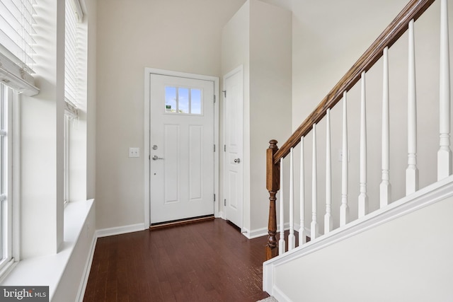 entryway featuring stairs, baseboards, and wood finished floors