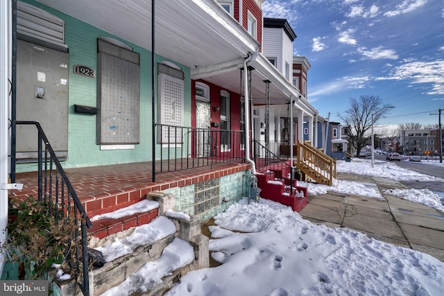 view of snow covered exterior with a porch