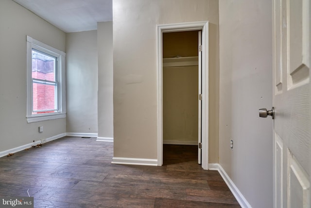 unfurnished bedroom with a closet and dark wood-type flooring