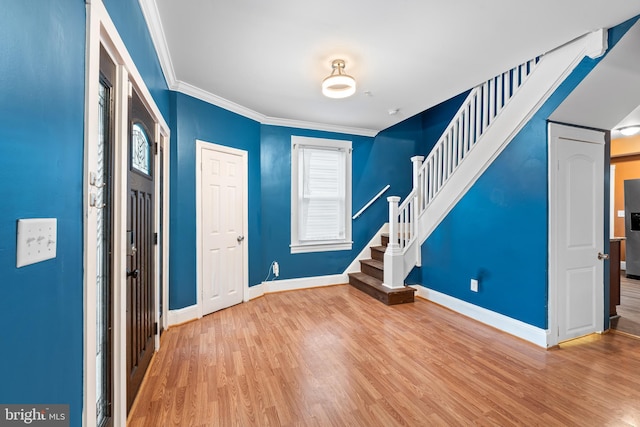 entryway featuring crown molding and light hardwood / wood-style floors