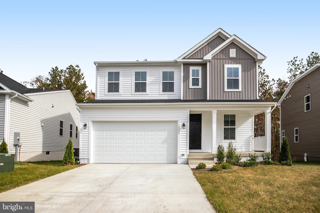 view of front facade featuring a porch, a garage, and a front lawn