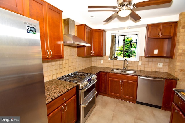 kitchen with dark stone counters, wall chimney range hood, sink, decorative backsplash, and appliances with stainless steel finishes