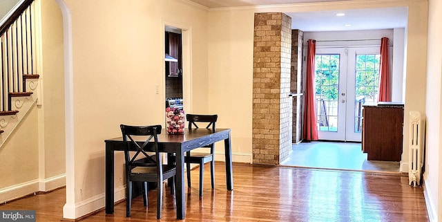 dining room with hardwood / wood-style flooring, ornamental molding, radiator heating unit, and french doors