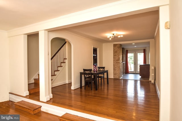 entrance foyer featuring french doors, dark hardwood / wood-style flooring, radiator, and ornamental molding