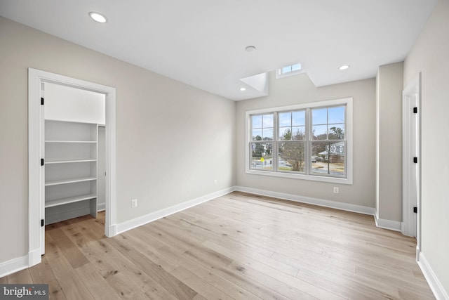 unfurnished bedroom featuring light hardwood / wood-style floors and a spacious closet