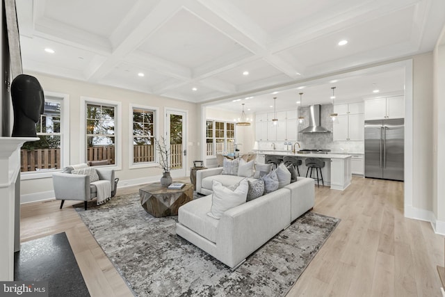 living room featuring beamed ceiling, coffered ceiling, and light hardwood / wood-style flooring