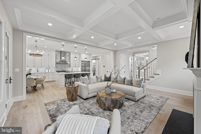 living room featuring beamed ceiling, light hardwood / wood-style floors, and coffered ceiling