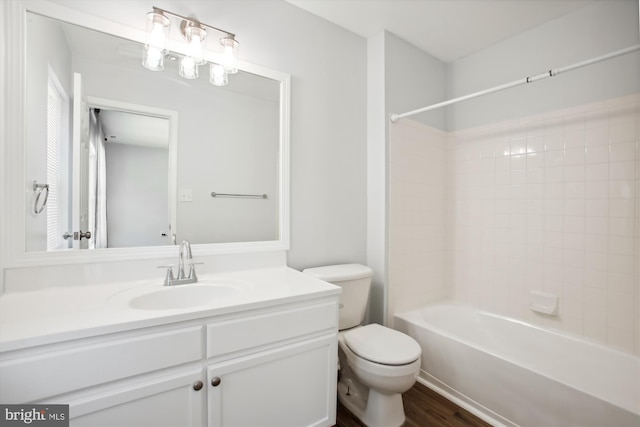 full bathroom featuring toilet, hardwood / wood-style floors, vanity, and tiled shower / bath combo