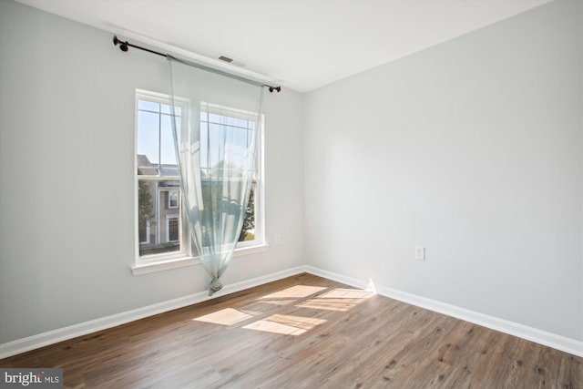 empty room with wood-type flooring and a wealth of natural light