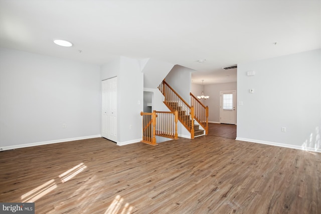 unfurnished living room with a chandelier and light wood-type flooring