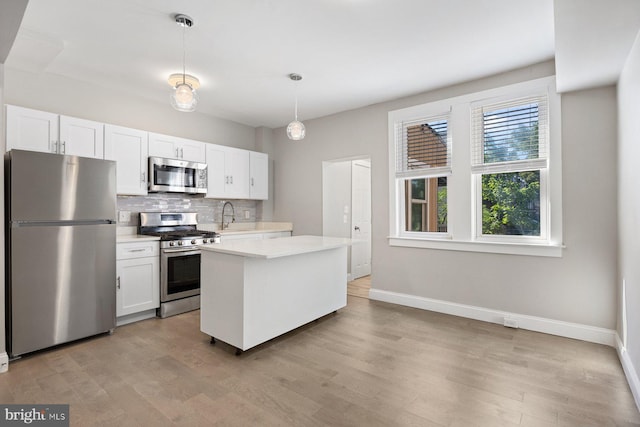 kitchen with white cabinets, decorative backsplash, stainless steel appliances, and a kitchen island