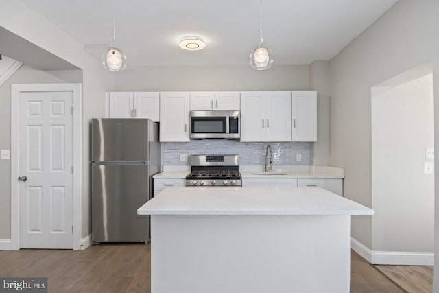 kitchen featuring appliances with stainless steel finishes, white cabinetry, pendant lighting, and sink