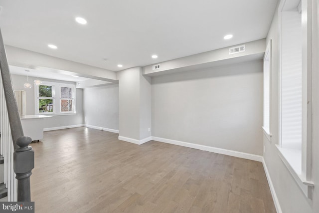 basement with hardwood / wood-style floors and a notable chandelier