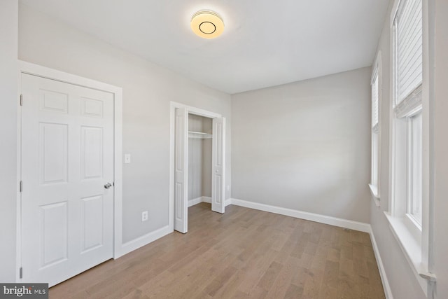 unfurnished bedroom featuring a closet and light wood-type flooring