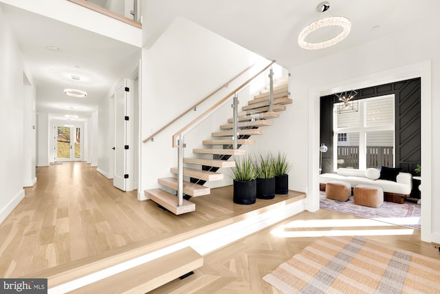 staircase featuring parquet floors and a notable chandelier