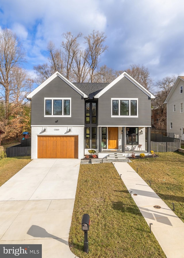 view of front of property with a front yard, a garage, and a porch