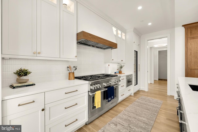 kitchen featuring white cabinetry, double oven range, backsplash, and light wood-type flooring