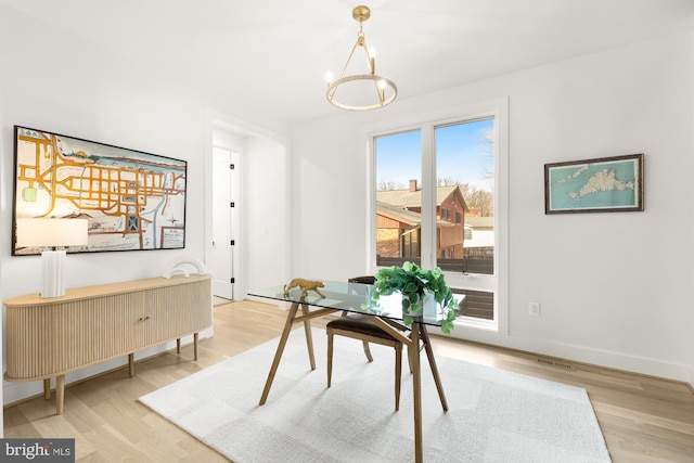 office space featuring a notable chandelier and light wood-type flooring