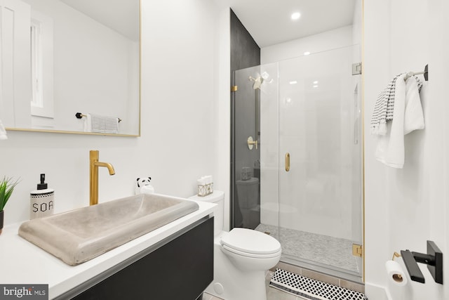 bathroom featuring vanity, tile patterned floors, a shower with shower door, and toilet