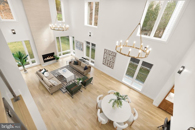 living room featuring a high ceiling, hardwood / wood-style flooring, and a large fireplace