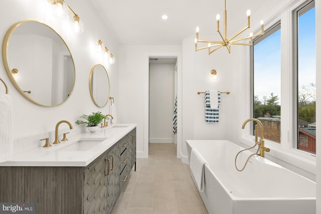 bathroom featuring vanity, tile patterned flooring, an inviting chandelier, and a tub