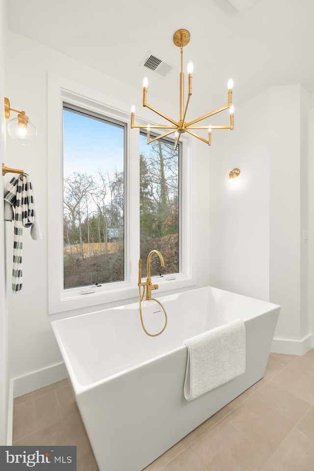 bathroom featuring a bath, tile patterned floors, and a chandelier