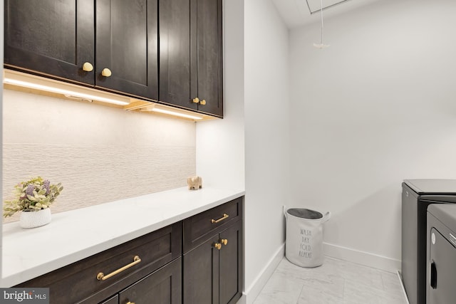 laundry room with washing machine and dryer and cabinets