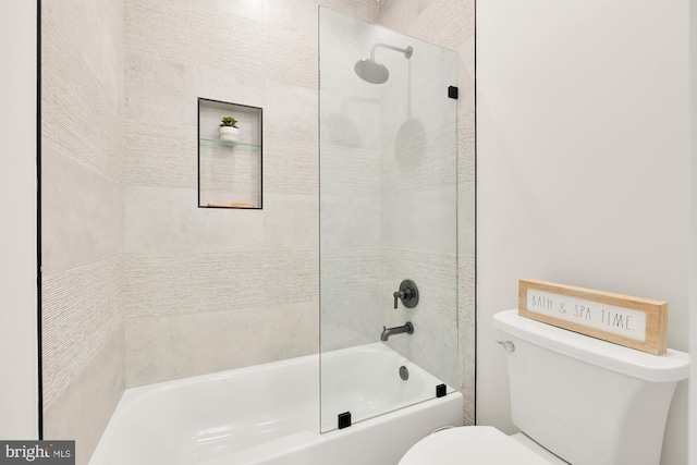 bathroom with tiled shower / bath and toilet