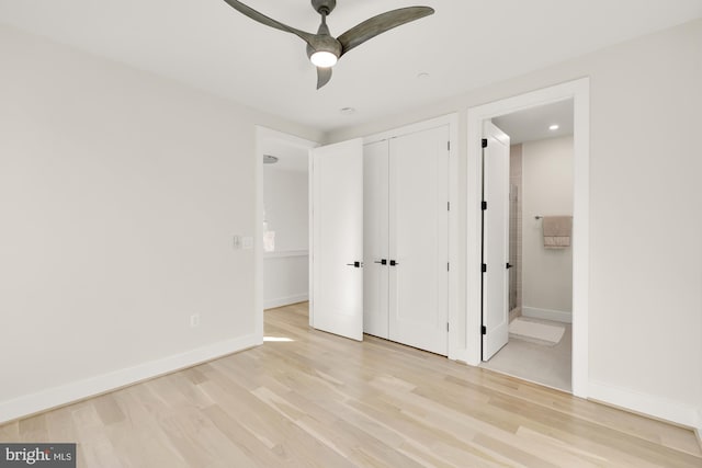 unfurnished bedroom featuring ceiling fan, light hardwood / wood-style floors, a closet, and ensuite bath