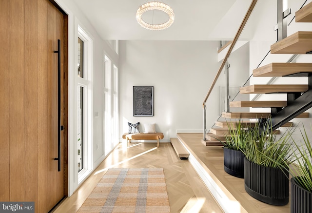 entryway featuring a chandelier and light parquet floors