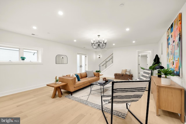 living room with a notable chandelier and light hardwood / wood-style floors