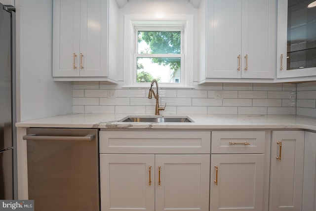 kitchen with backsplash, white cabinetry, sink, and appliances with stainless steel finishes