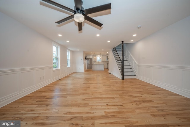 unfurnished living room featuring ceiling fan and light hardwood / wood-style flooring