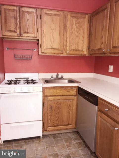 kitchen featuring stainless steel dishwasher, white range with gas cooktop, and sink