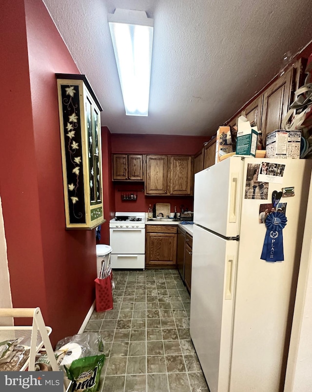 kitchen featuring a textured ceiling and white appliances