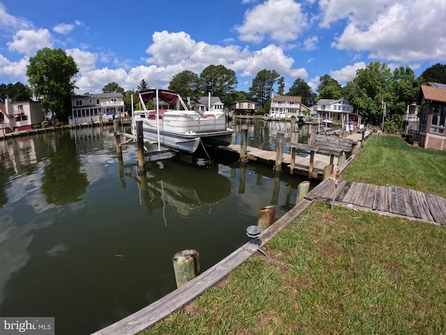 dock area featuring a water view and a lawn