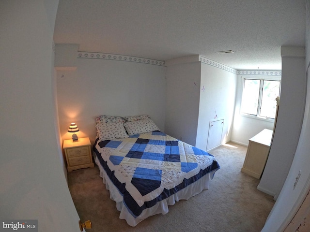 bedroom with a textured ceiling and carpet flooring