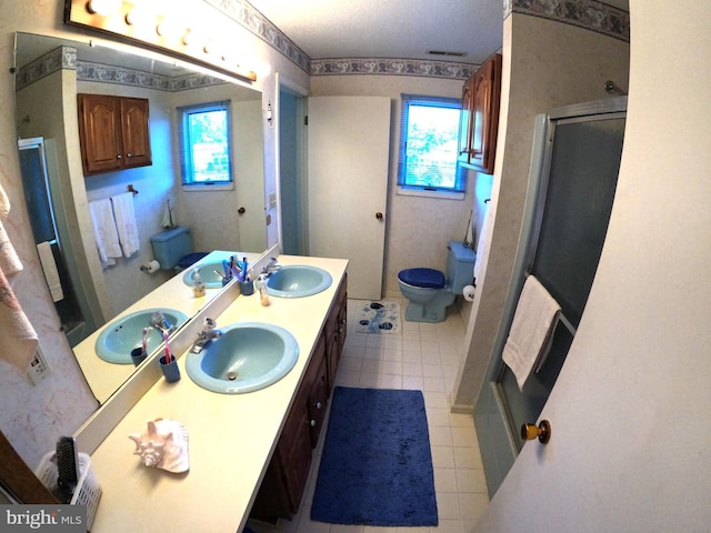 bathroom with vanity, tile patterned flooring, a shower with shower door, and plenty of natural light